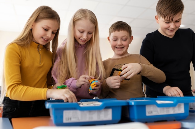 Free Photo four kids using electronic parts to build a robot