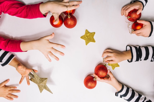 Free Photo four pairs of hands and christmas balls