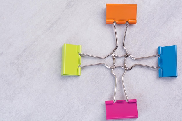 Four paper clips on white surface.