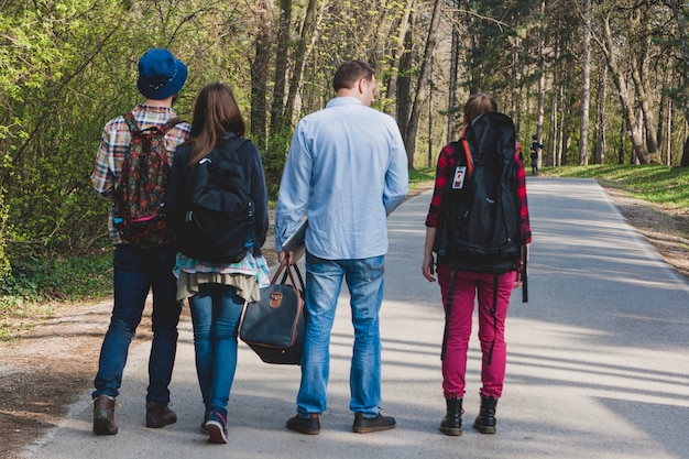 Four tourist friends walking on path