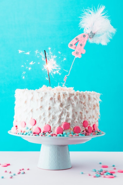 Free Photo fourth birthday cake with burning sparkler on white surface