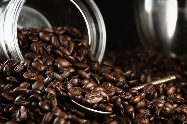 Free photo fragrant freshly roasted coffee beans are scattered from the jar onto the countertop copy space banner closeup selective focus