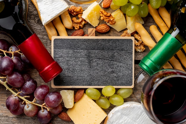 Free Photo frame beside wine bottles and grape and cheese