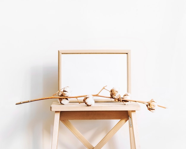 Free photo frame and elegant branch on stool