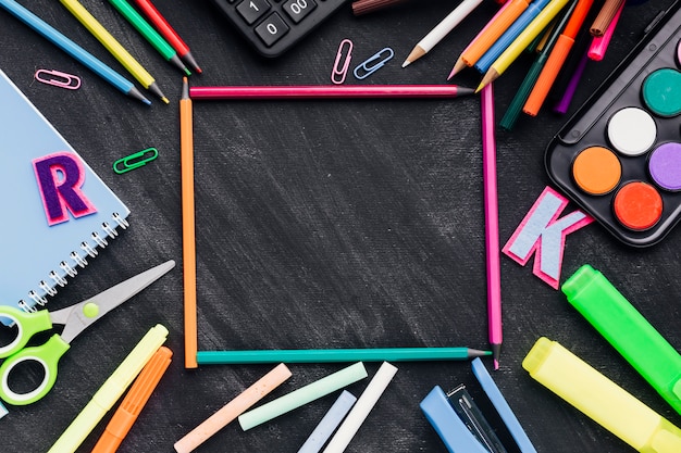 Free photo frame made of stationery over chalkboard