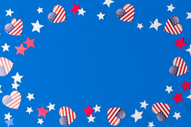 Free photo a frame made with heart shape american flags and stars for writing the text on blue background