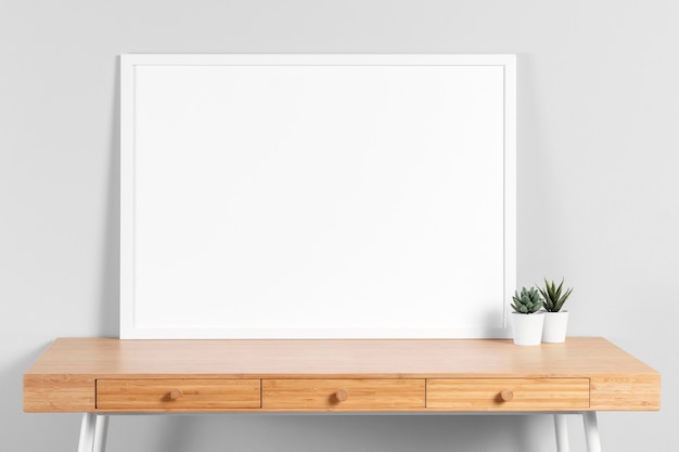 Free photo frame mock up on table with plant