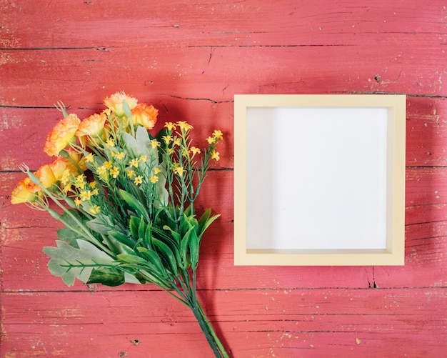 Free photo frame with yellow flowers on pink wooden background