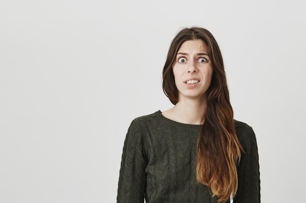 Freak out young woman cringe from something disgusting or strange, grimacing bothered