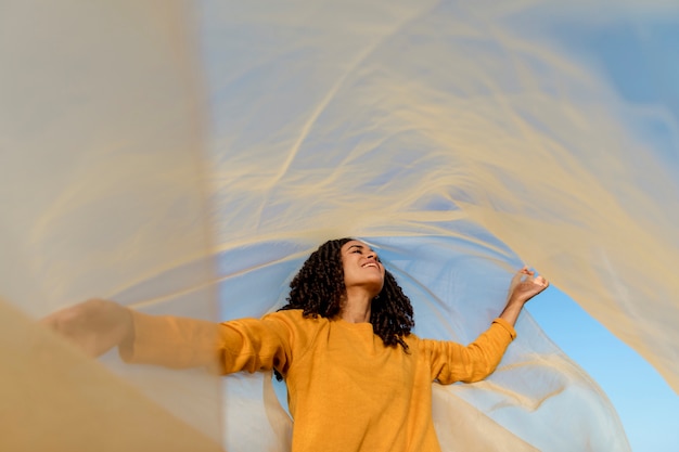 Free photo freedom concept with woman holding cloth in nature