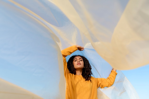 Free photo freedom concept with woman holding cloth in nature