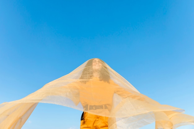 Free photo freedom concept with woman holding cloth in nature