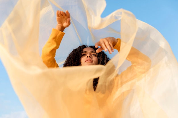 Free photo freedom concept with woman holding cloth in nature