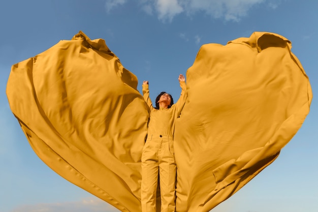 Free photo freedom concept with woman holding cloth in nature