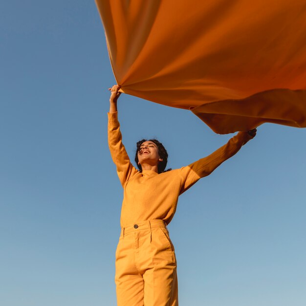 Freedom concept with woman holding cloth in nature