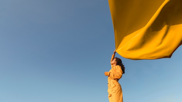 Freedom concept with woman holding cloth in nature