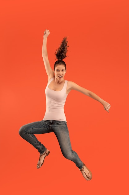 Free photo freedom in moving. mid-air shot of pretty happy young woman jumping