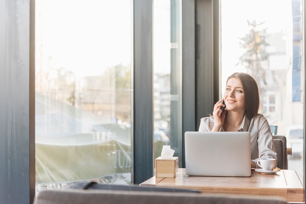 Freelance woman working with laptop in coffee shop