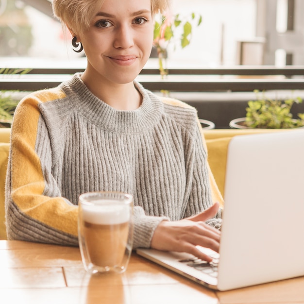 Free photo freelance woman working with laptop in coffee shop