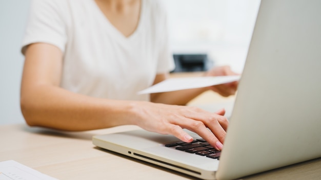 Freelance young Asia businesswoman casual wear using laptop working in living room at home.