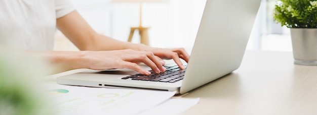 Freelance young Asian businesswoman casual wear using laptop working in living room at home.