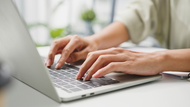 Freelance young businesswoman casual wear using laptop working in living room at home.