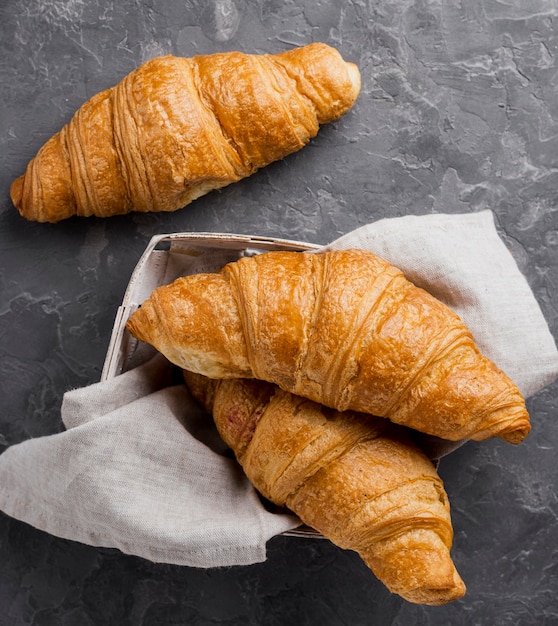 Free photo french croissants in cardboard box and cloth