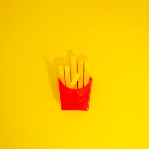 French fries replica over yellow background