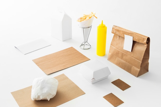 French fries; sauce bottle and food parcel on white background