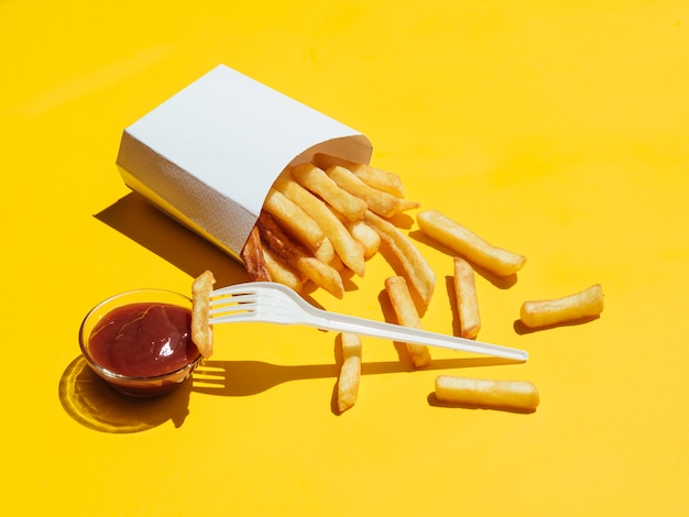 Free photo french fries with ketchup and plastic fork