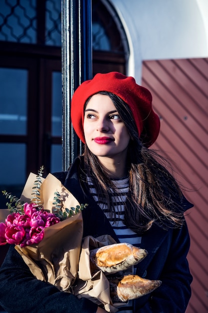 Free Photo french woman with baguettes on the street in beret