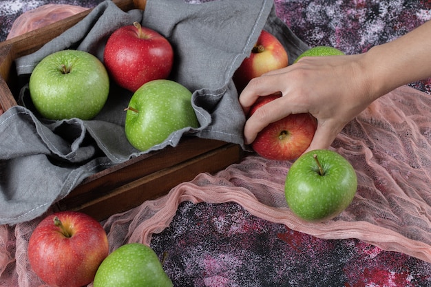 Fresh apples in a rustic wooden container.