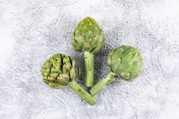 Free photo fresh artichokes on a light gray . top view.