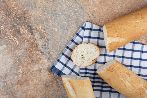 Fresh baguette slices on striped tablecloth