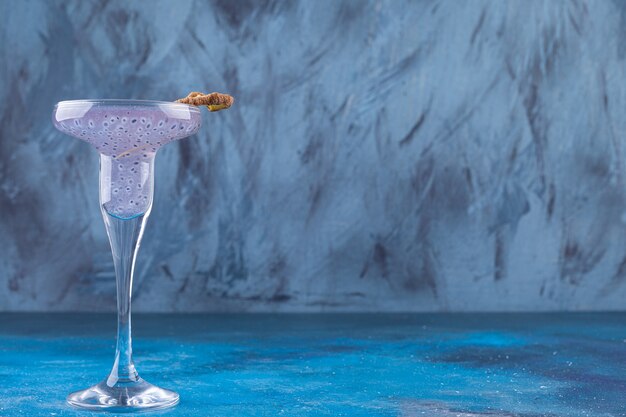 Fresh basil seeds cocktail placed on blue background. 