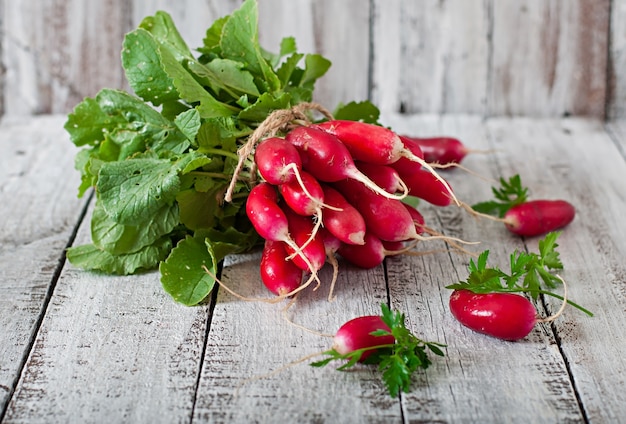 Free photo fresh bunch of radishes on old wooden background