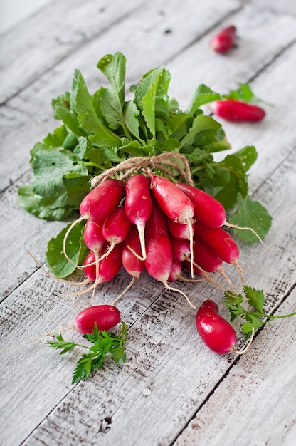 Free photo fresh bunch of radishes on old wooden background