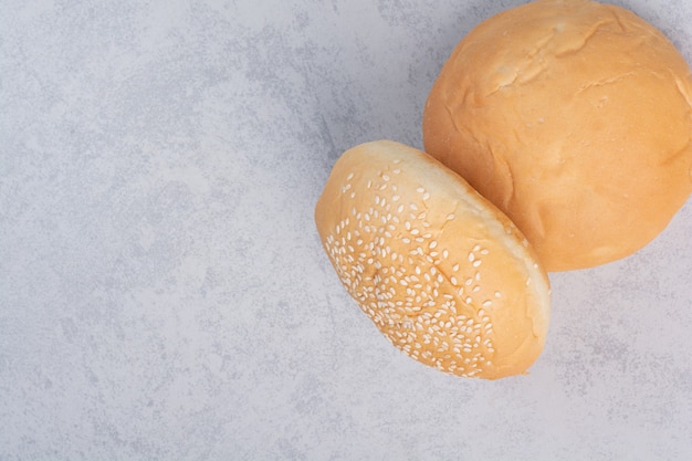 Free photo fresh buns with sesame seeds on stone surface