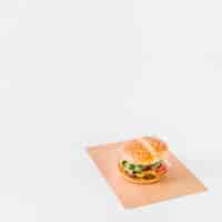 Free photo fresh burger on brown paper over white background