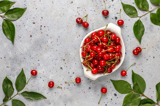 Fresh cherry on plate on grey table.