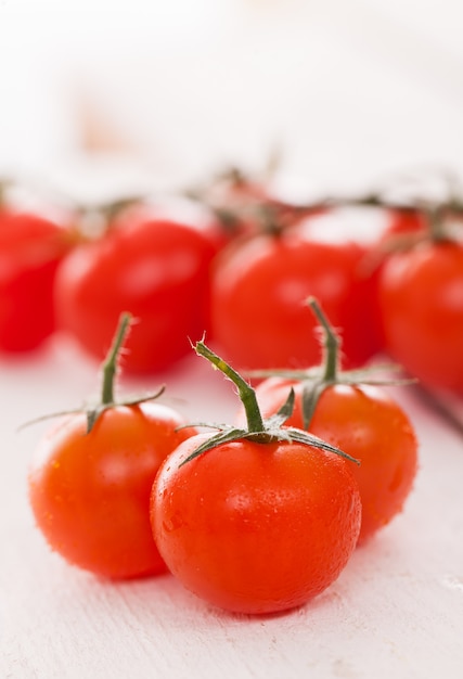 Fresh cherry tomatoes on a white surface 