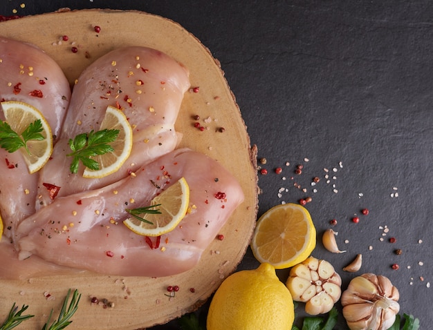 fresh chicken meat portions for cooking and barbecuing with fresh seasoning. Raw uncooked chicken leg on cutting board.