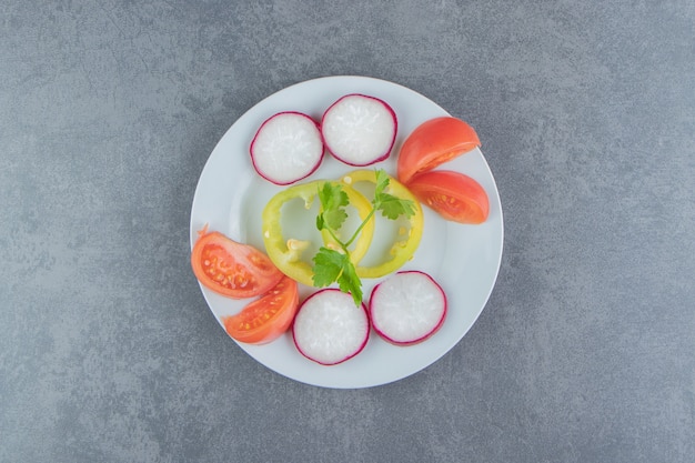 Fresh chopped vegetables on white plate.