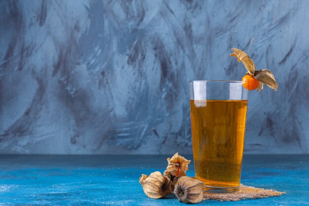 Fresh cocktail and ripe kumquats placed on stone background. 