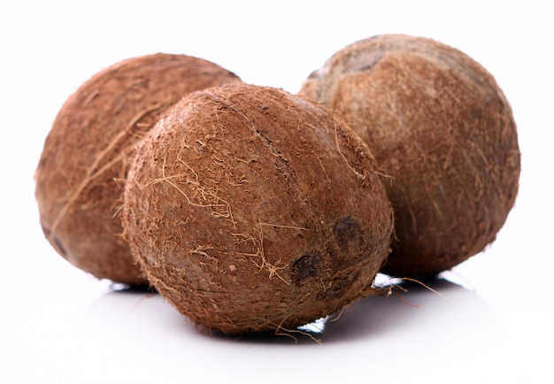 Fresh coconuts on white surface