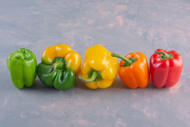 Fresh colorful organic peppers placed on stone background.