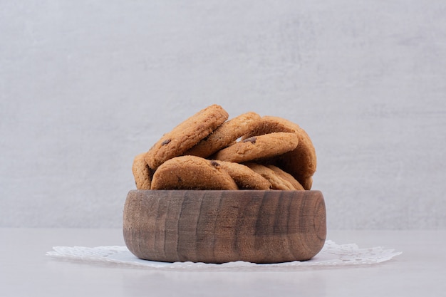 Fresh cookies on wooden plate .