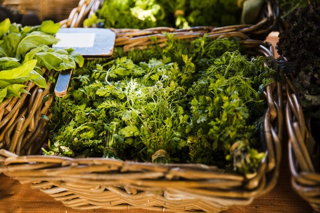 Fresh coriander in wicker basket for sale at supermarket