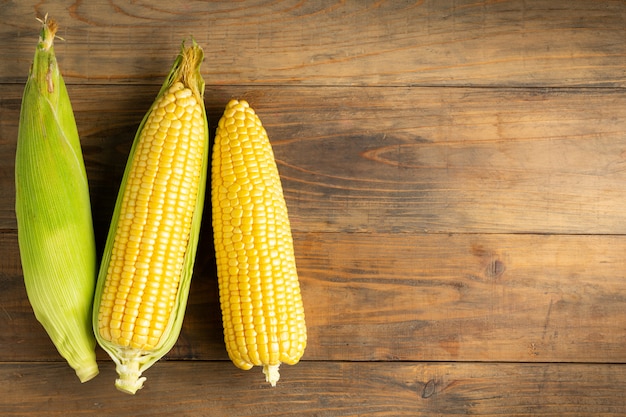 Fresh corn on wooden table.