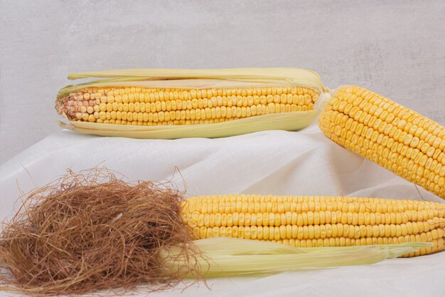 Fresh corns on cobs on white.